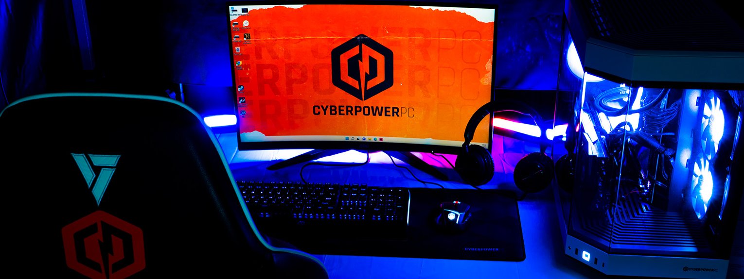 Gaming set up, including a monitor with CyberPowerPC UK branded screen saver, keyboard, headset, gaming chair and desktop. 