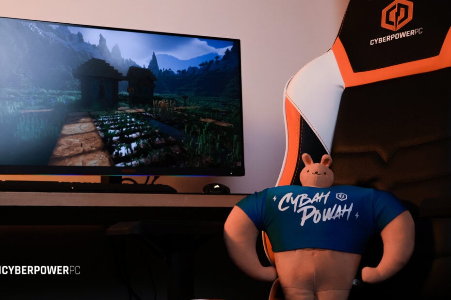 CyberPowerPC UK gaming chair sat at a gaming desktop setup displaying Minecraft with 4k raytracing.