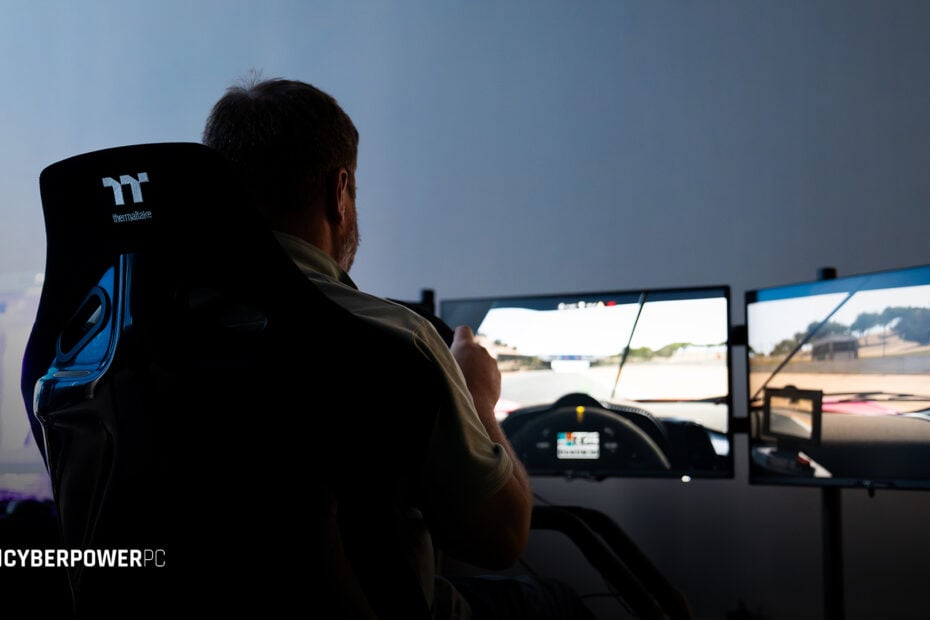A man sat in a racing rig playing a driving simulator game